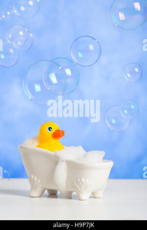 Badezeit Spaß mit Gummiente in Badewanne mit schwimmenden Bläschen Stockfoto