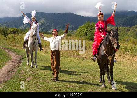 Einheimische Frauen und Mann in traditioneller Kleidung bei nationalen Folklore spielen in Almaty, Kasachstan. Stockfoto