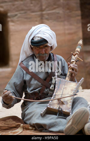 Beduinen senior Mann spielen Saiteninstrument auf die antike Stätte von Petra in Jordanien Stockfoto