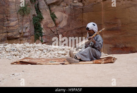 Beduinen senior Mann spielen Saiteninstrument auf die antike Stätte von Petra in Jordanien Stockfoto