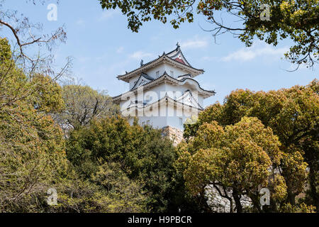 Japan, Akashi schloss, AKA Kishun-jo. drei-stöckigen Hitsujisaru Yagura, Revolver, mit Bäumen umgeben. Spingtime, blau, aber teilweise bewölktem Himmel. Stockfoto