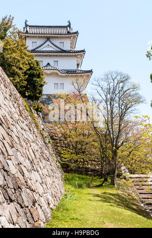 Japan, Akashi schloss, AKA Kishun-jo. drei-stöckigen Hitsujisaru Yagura, Revolver, auf Ishigaki Steinmauern. Frühling mit Blau teilweise bewölktem Himmel. Stockfoto