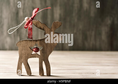 ein rustikales Holz Ornament in Form von einem Rentier, auf einer rustikalen Holzoberfläche Stockfoto