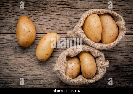 Frische Bio-Kartoffeln in Hanf Willen Tasche auf rustikalen hölzernen Hinterg Stockfoto