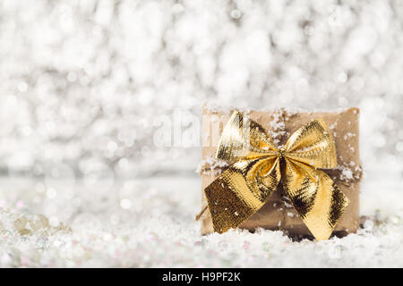 Weihnachtsgeschenk auf verschneiten unscharfen Hintergrund Stockfoto