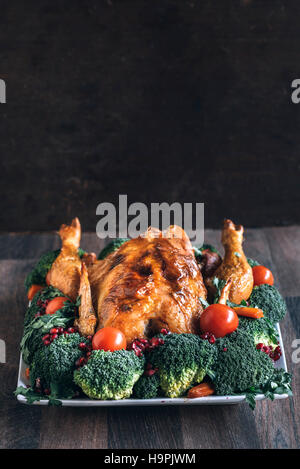 Ganze gebratene Hähnchen und Gemüse auf dem Holztisch mit dem leeren Raum Stockfoto
