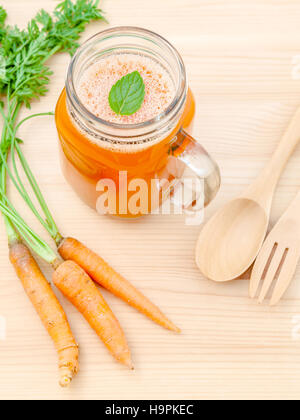 Gläser Karottensaft mit Karotte Wurzeln auf hölzernen Hintergrund. G Stockfoto