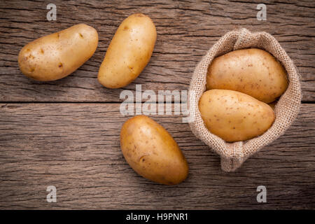 Frische Bio-Kartoffeln in Hanf Willen Tasche auf rustikalen hölzernen Hinterg Stockfoto