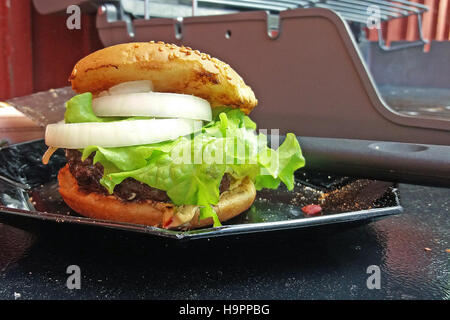 Hausgemachte Hamburger. Gas-Grill auf Hintergrund. Stockfoto