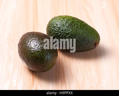 Grüne Avocados auf Holzbrett Stockfoto