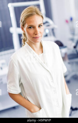 Attraktive Zahnärztin posiert in der modernen Zahnarztpraxis Stockfoto