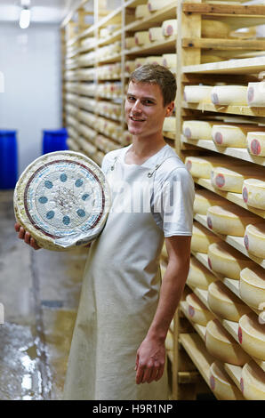 Evillers, Frankreich - 31. August 2016: Käser hält ein Rad von Comte Käse Reifung Keller in Franche Comte Creamery, in Frankreich Stockfoto