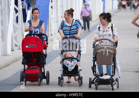 Gruppe von Müttern, die Kinderwagen schieben, über die Puente de Hierro in Zaragoza, Spanien Stockfoto