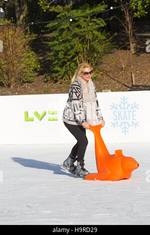 Bournemouth, Dorset, Großbritannien, 25. November 2016. Besucher genießen Schlittschuhlaufen auf der Outdoor eislaufen Eisbahn in Bournemouth untere Gärten im November. im freien Eislaufbahn. Frau Skaten mit Dichtung. Credit: Carolyn Jenkins/Alamy leben Nachrichten Stockfoto