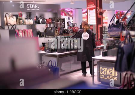 London, London, UK. 25. November 2016. Eine Frau schaut Handtaschen in Debenhams auf der Oxford Street am schwarzen Freitag, in London, Großbritannien am 25. November 2016. © Tim Irland/Xinhua/Alamy Live-Nachrichten Stockfoto