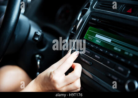 Bild einer Frau Hand Drehen des Radios im Auto beschnitten Stockfoto