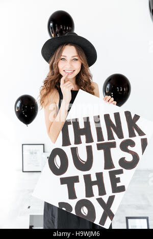 Porträt von lächelnden süße junge Frau mit schwarzen Luftballons und weiße Tafel Stockfoto