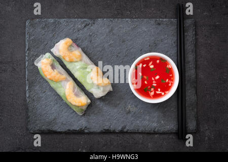 Vietnamesische Rollen mit Gemüse, Reisnudeln und Garnelen auf schwarzem Schiefer Hintergrund Stockfoto