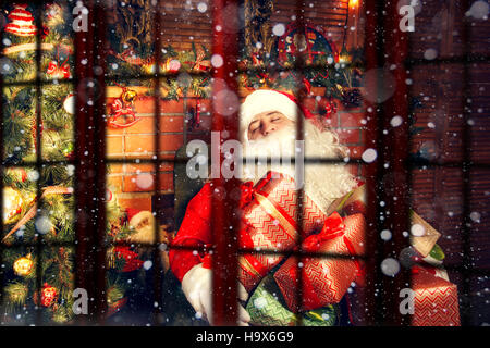 Echten Weihnachtsmann. Schlafen im Wohnzimmer in der Nähe der Weihnachtsbaum Weihnachtsmann.  Blick von außen durch die Fenster. Stockfoto