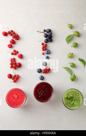 Gläser mit Smoothieand Früchten auf konkreten Hintergrund, Lebensmittel-Draufsicht Stockfoto
