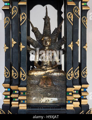 Messing Buddha-Statue mit sieben Kopf Drachen in den kleinen hölzernen Altar. Stockfoto