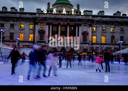 Skater Spaß auf dem Eis am Somerset House in London in der Abenddämmerung. Stockfoto