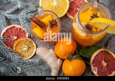 Winter Heilung Ingwer Drink mit Zitrone, Honig und Orangen. Zimt, Sternanis, Tannengrün, Mandarinen, getrocknete Grapefruit. Winter Weihnachten Hintergrund Stockfoto