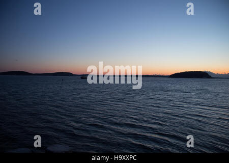 Bar Harbor's Bar Island bei Sonnenaufgang im Winter fängt die ruhige Schönheit der Küstenlandschaft von Maine ein. Die beschauliche Szene zeigt die einzigartige Kombination aus Meer, Insel und Wald während der kalten Jahreszeit und bietet einen legendären Blick auf den Nationalpark im Winter. Stockfoto