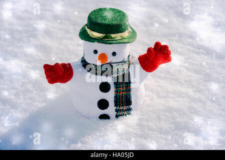 Schneemann stehen unter Schneehaufen. Morgensonne wärmt im Winter. Stockfoto