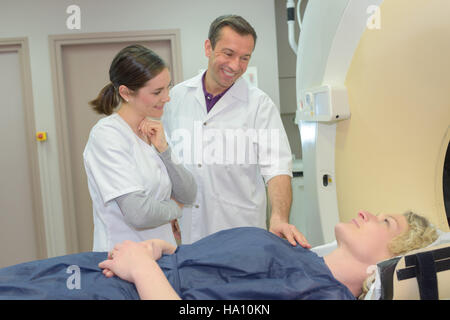 Angehörigen des medizinischen Personals beruhigend Patienten Eingabe MRT-scanner Stockfoto