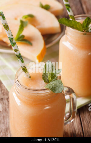 Smoothies-Melone mit Minze-Makro in einem Glas auf dem Tisch. vertikale Stockfoto