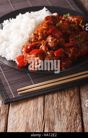 Schweinefleisch mit Gemüse und Reis Beilage Nahaufnahme im asiatischen Stil. vertikale Stockfoto
