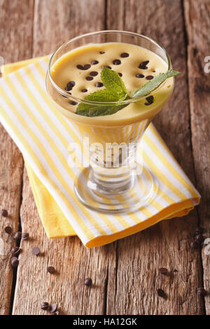 Italienische Zabaione Dessert mit Schokolade hautnah in einem Glas auf dem Tisch. vertikale Stockfoto