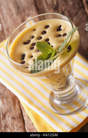 Italienische Zabaione-Creme mit Schokolade und Minze hautnah in einem Glas auf dem Tisch. vertikale Stockfoto
