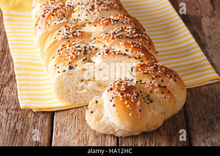in Scheiben geschnitten Laib geflochtene Sesam close-up auf dem Tisch. horizontale, rustikalen Stil Stockfoto