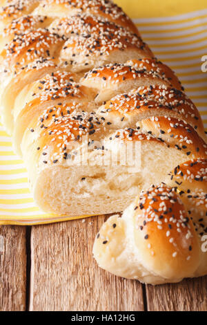 in Scheiben geschnitten Laib geflochtene Sesam close-up auf dem Tisch. vertikale, rustikalen Stil Stockfoto