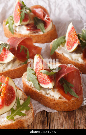 Gesunde Sandwiches mit Feigen, Parmaschinken, Rucola und Frischkäse-close-up auf dem Tisch. vertikale. rustikale Stockfoto