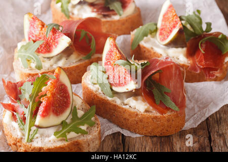 Gesunde Sandwiches mit Feigen, Parmaschinken, Rucola und Frischkäse-close-up auf dem Tisch. horizontale. rustikale Stockfoto