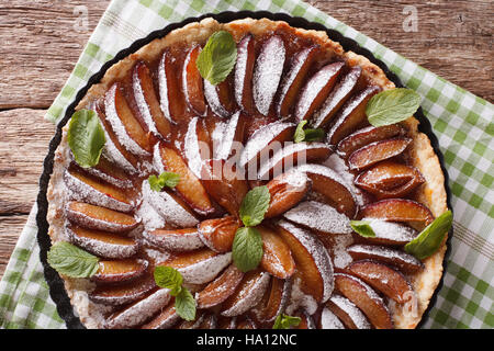 Leckere Kuchen: Pflaumen-Tarte mit Minze und Puderzucker Nahaufnahme auf dem Tisch. Horizontale Ansicht von oben Stockfoto