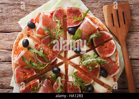 Pizza mit Feigen, Schinken, Kräutern, Oliven und Mozzarella Closeup auf dem Tisch. Horizontale Ansicht von oben Stockfoto