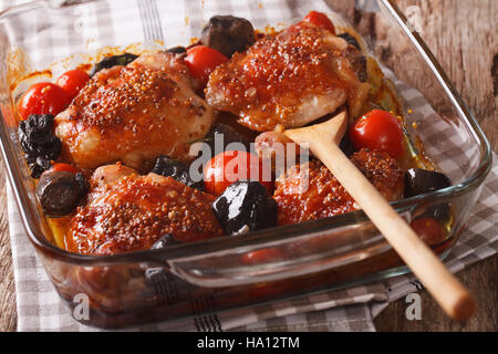 Leckeres Essen: Hühnerkeule gebacken mit Tomaten und Pilzen hautnah in Auflaufform auf den Tisch. horizontale Stockfoto