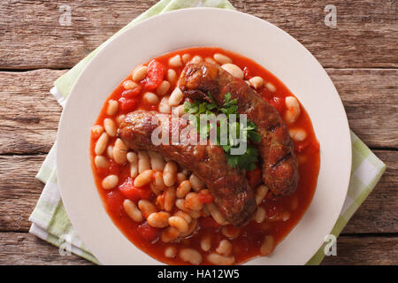 Bohnen mit gegrillten Würstchen, traditionelle europäische hausgemachte Mahlzeit mit einer Großaufnahme Teller auf den Tisch. horizontale Ansicht von oben Stockfoto