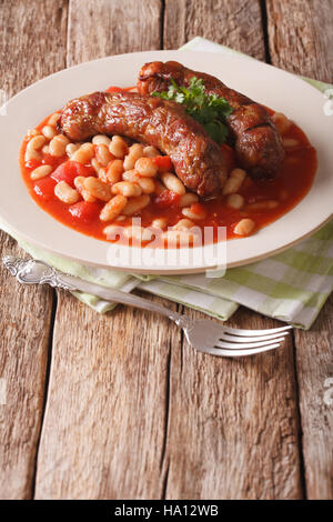 Bohnen mit gegrillten Würstchen, traditionelle europäische hausgemachte Mahlzeit mit einer Großaufnahme Teller auf den Tisch. vertikale Stockfoto