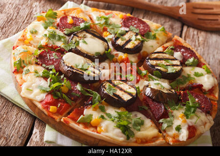 Pizza mit gegrillten Auberginen, Wurst, Mais und Käse Nahaufnahme auf dem Tisch. Horizontale Stockfoto