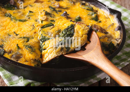 Omelette mit Spinat, Käse und Champignons in einer Pfanne Großaufnahme auf dem Tisch. horizontale Stockfoto