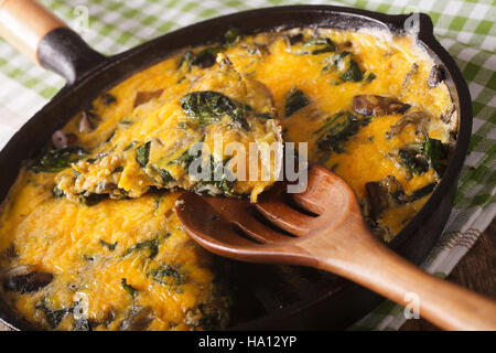 heißen Frittata mit Spinat, Käse und Champignons in einer Pfanne Großaufnahme auf dem Tisch. horizontale Stockfoto