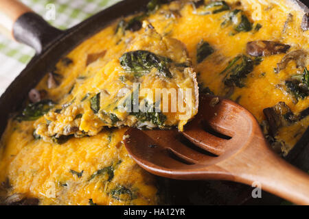 Frittata mit Spinat, Käse und Pilzen auf der Pfanne-Makro. horizontale Stockfoto