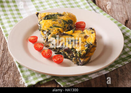 Frittata mit Spinat, Käse und Champignons auf einem Teller mit einer Tabelle Großaufnahme Scheiben. horizontale Stockfoto