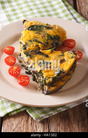 Frittata mit Spinat, Cheddar-Käse und Pilze auf einer Platte auf eine Tabelle Nahaufnahme geschnitten. vertikale Stockfoto