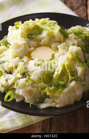 Hausgemachte irische Kartoffel Colcannon mit grünen und Butter auf einem Teller-Makro. Vertikal Stockfoto